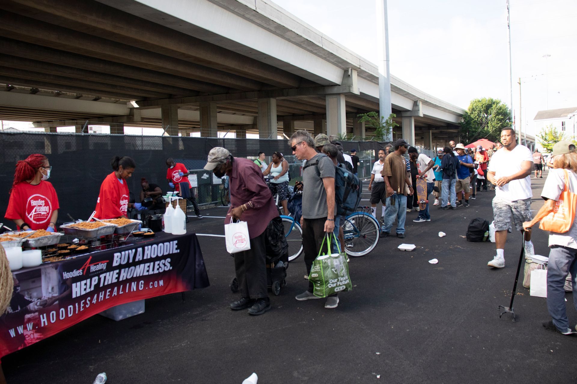 A group of people are standing around a table that says buy a room