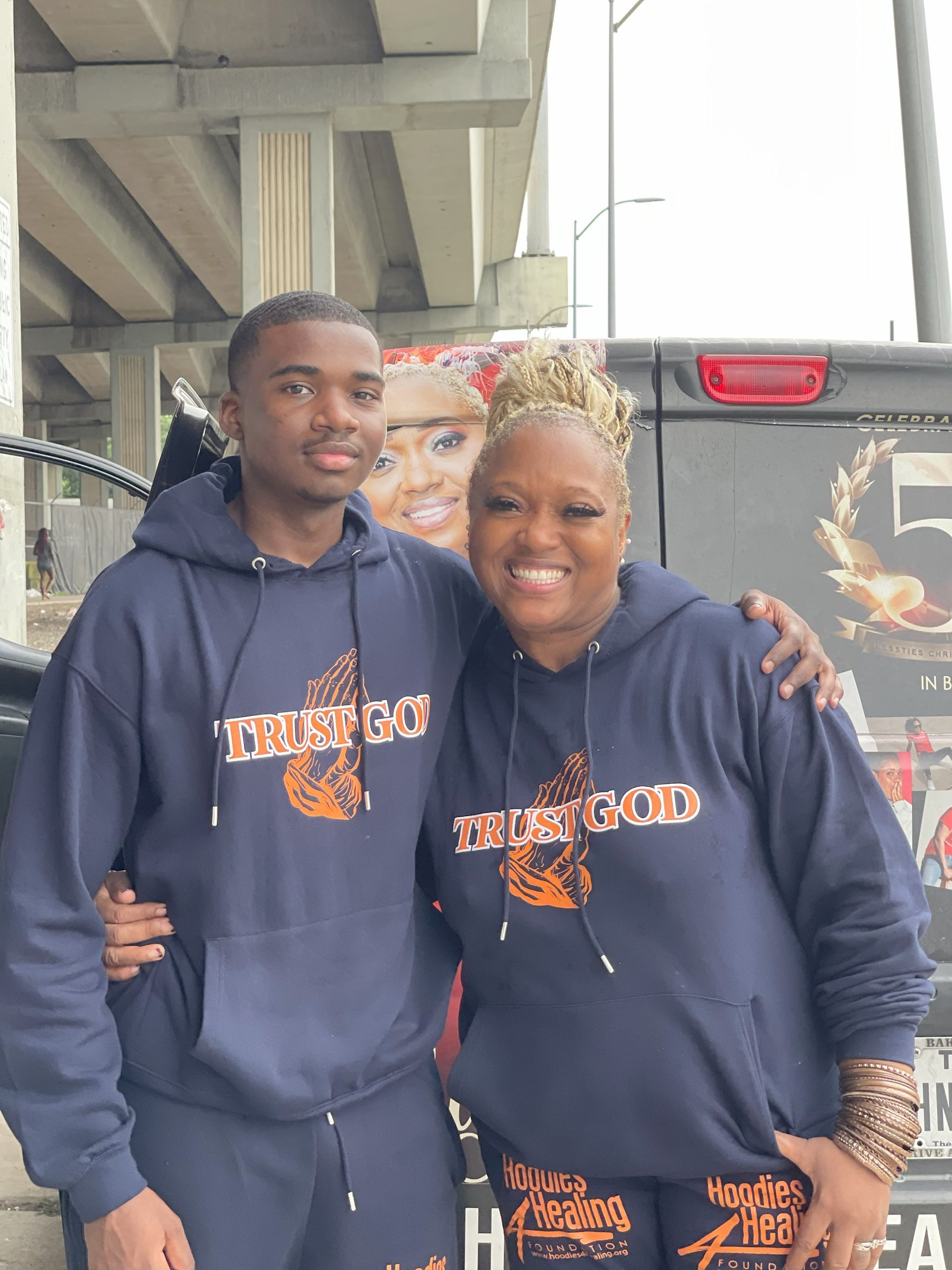 A man and a woman are posing for a picture in front of a truck.