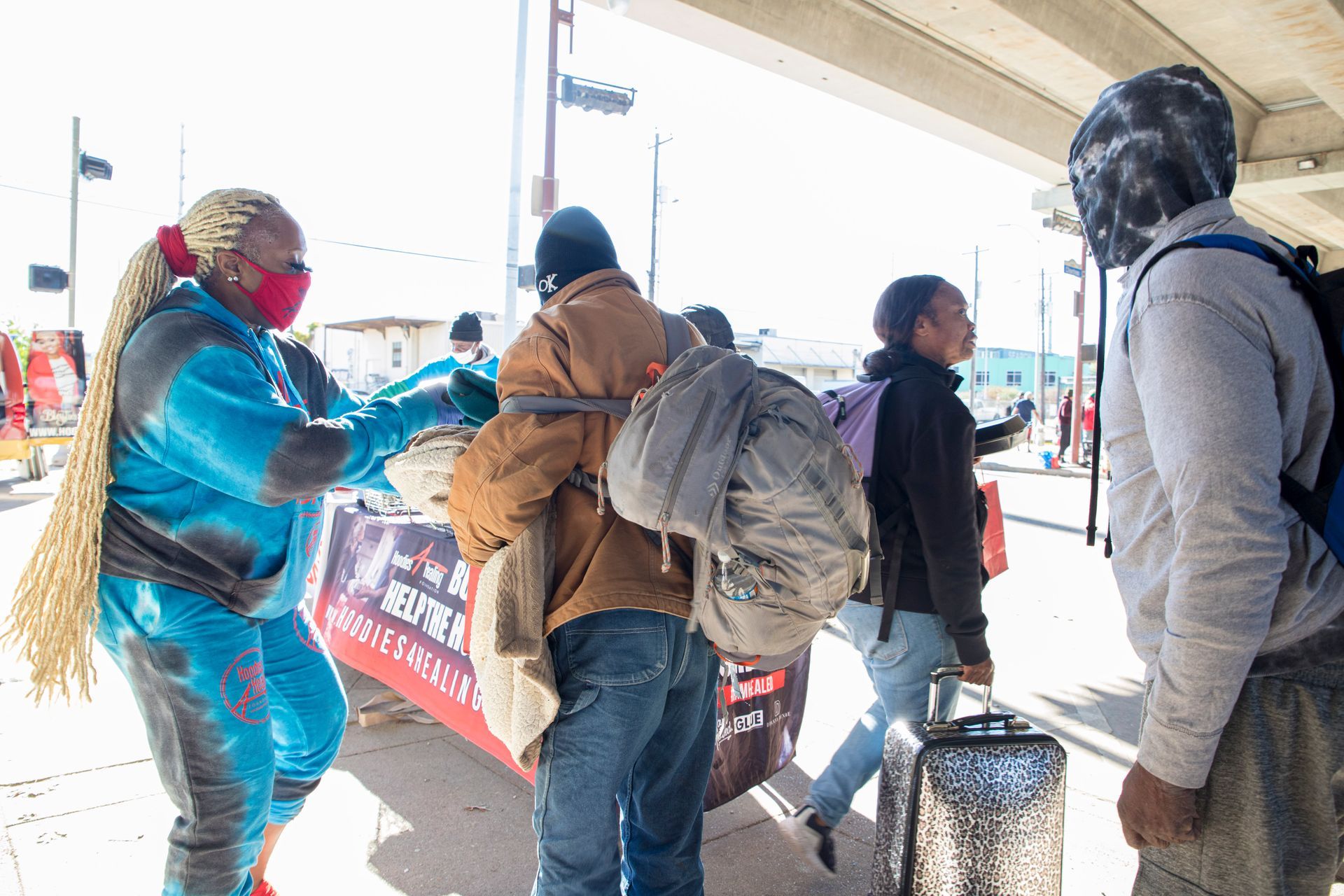 A group of people are standing next to each other on a sidewalk.