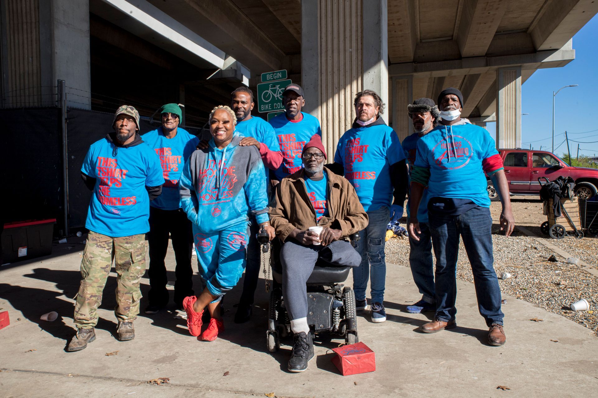 A group of people posing for a picture with one man in a wheelchair.