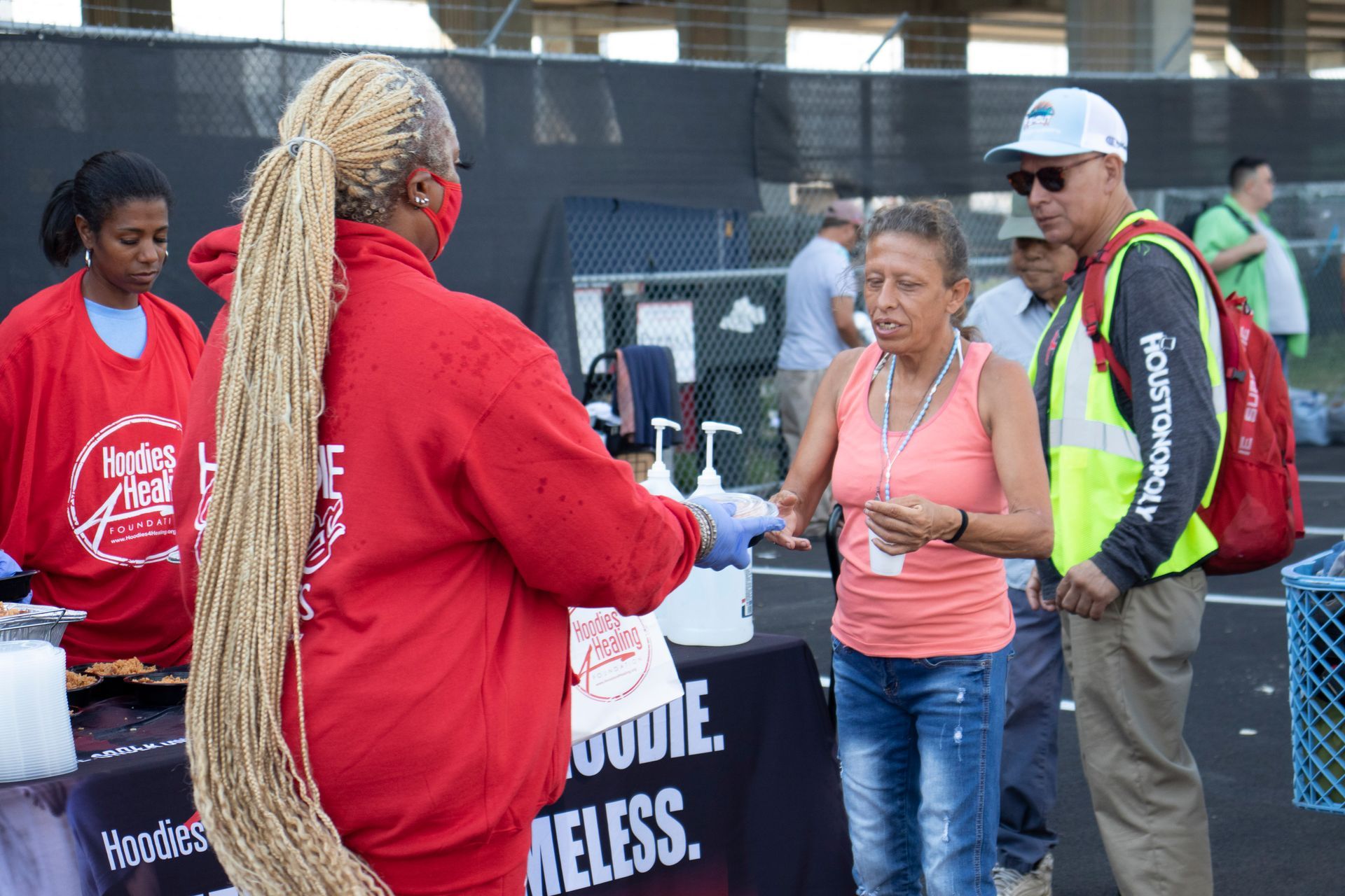 A group of people are standing around a table talking to each other.