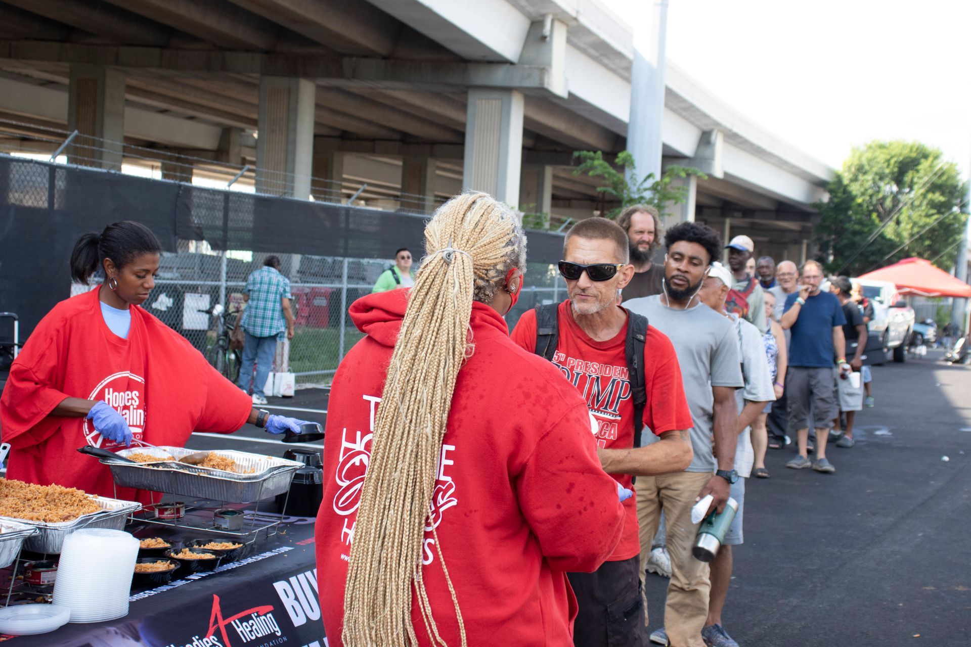 A group of people are standing in line at a food stand.