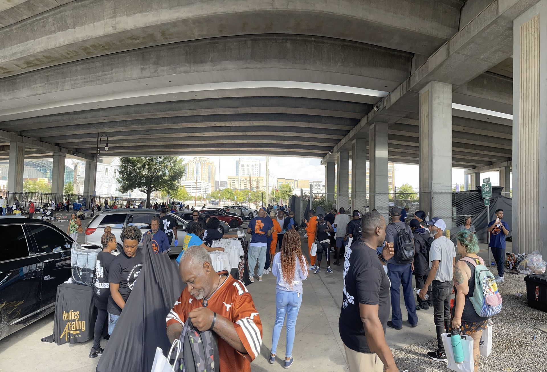 A group of people are standing under a bridge.