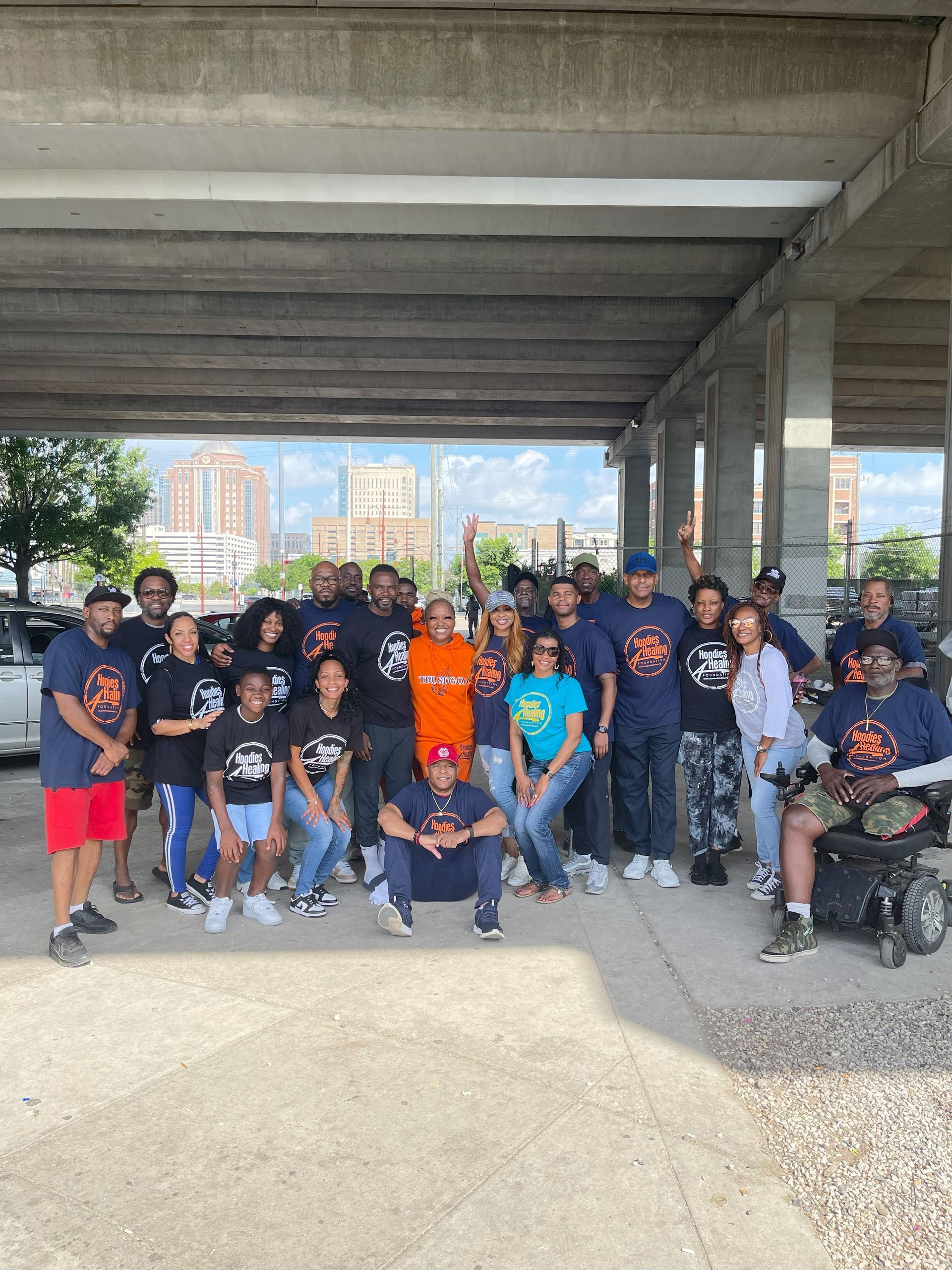 A group of people are posing for a picture under a bridge.