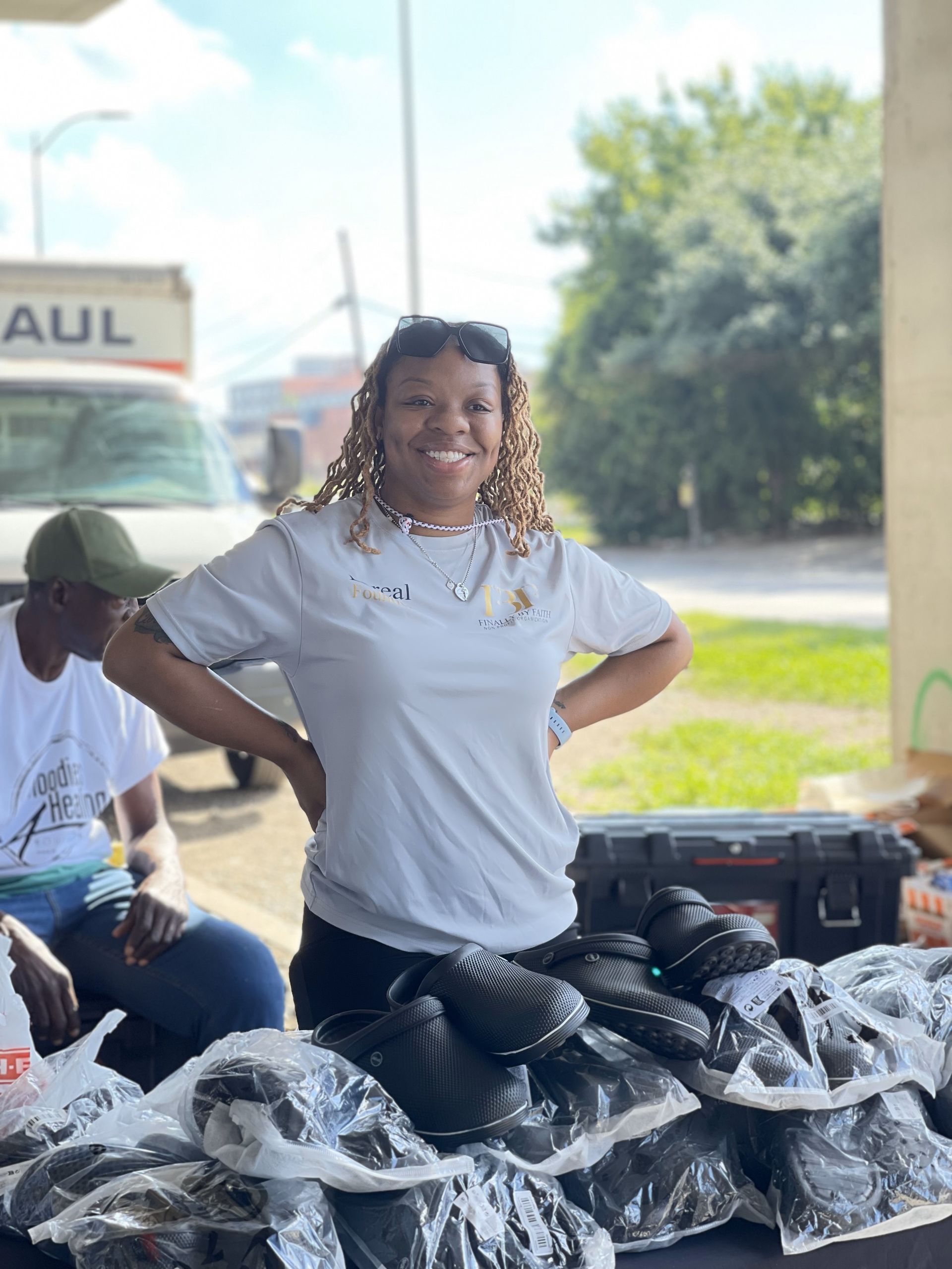 A woman is standing in front of a table filled with bags of food.