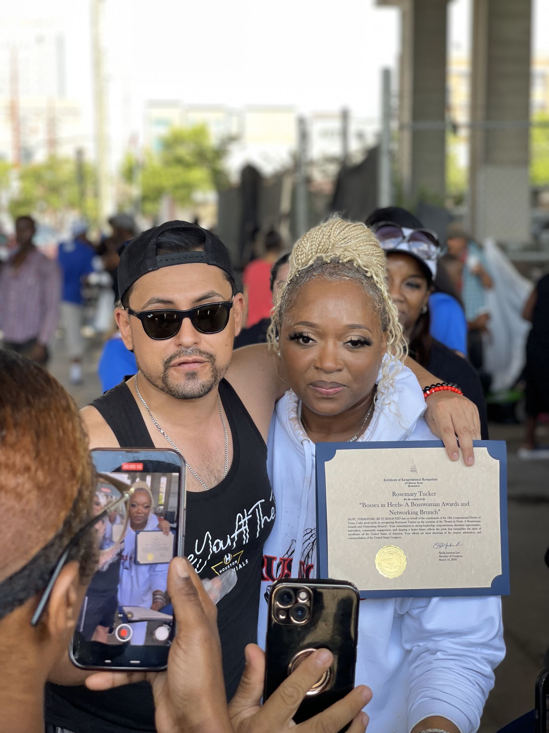A man and a woman are posing for a picture while holding a certificate.