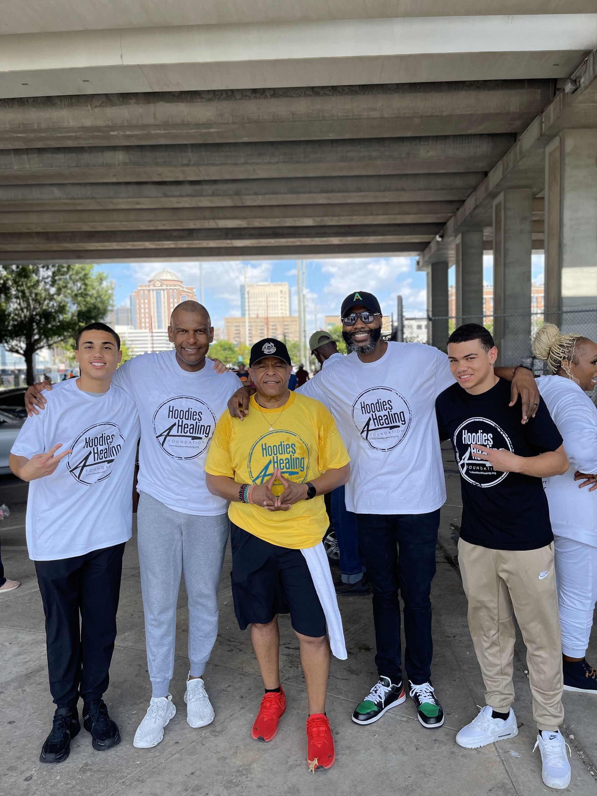 A group of young men are posing for a picture under a bridge.