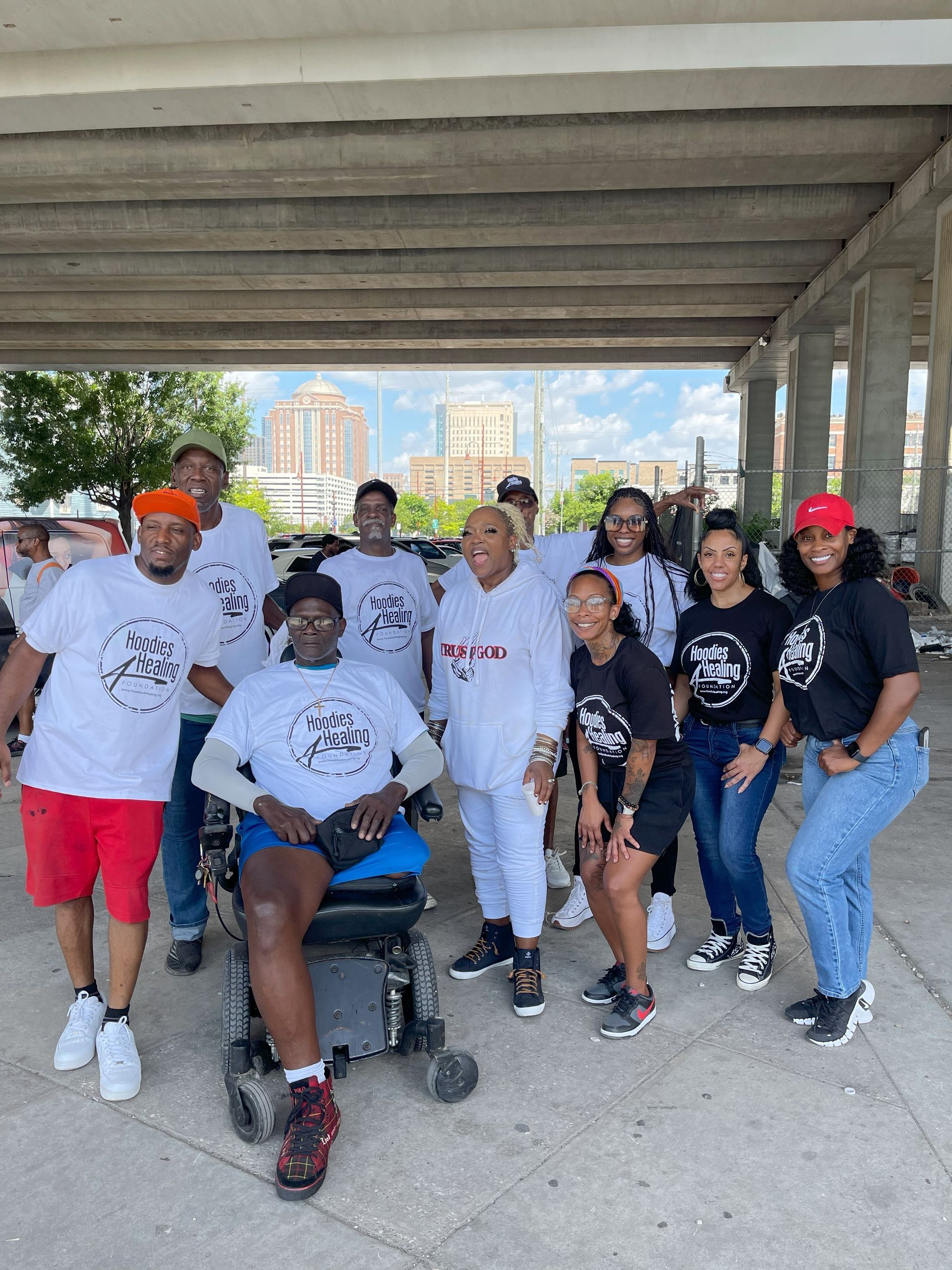 A group of people are posing for a picture with a man in a wheelchair.