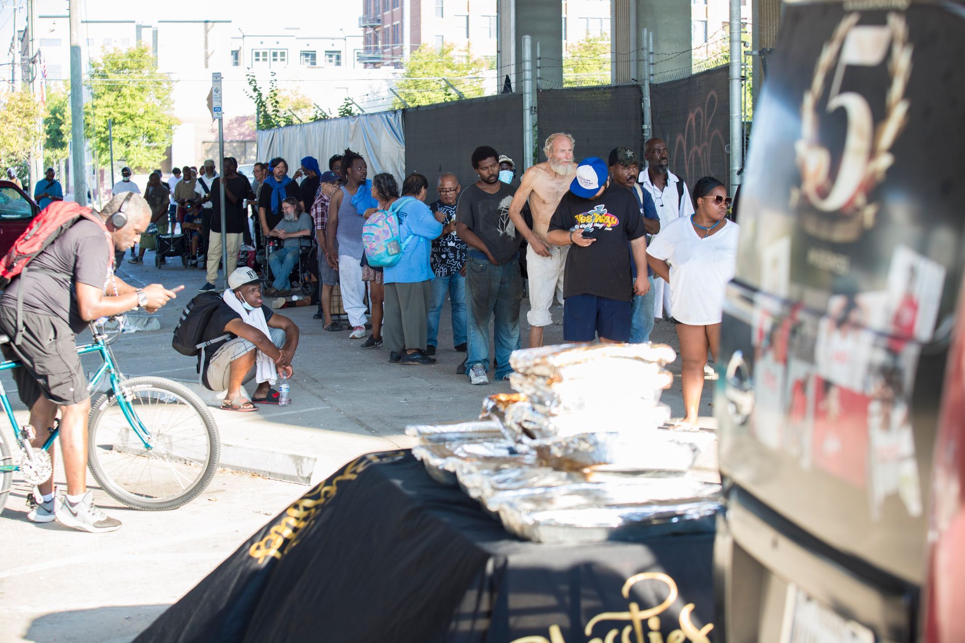 A group of people are standing in front of a building with the number 5 on it.