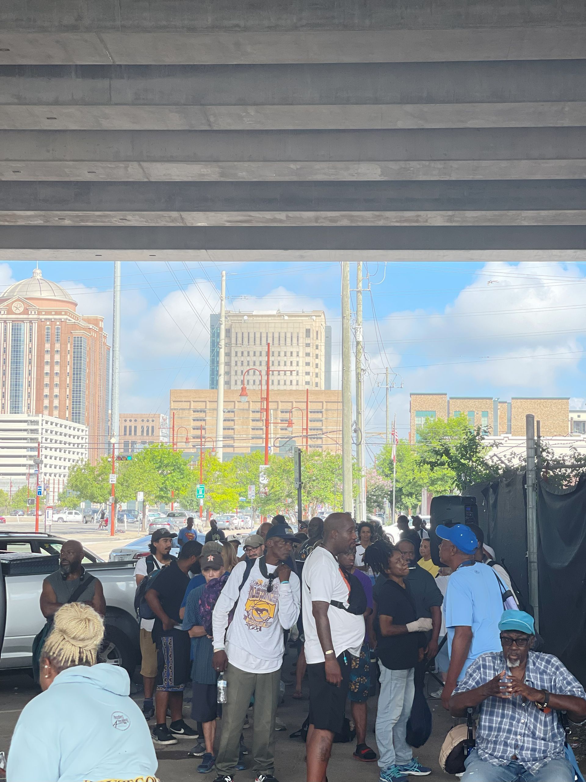 A group of people are standing under a bridge.