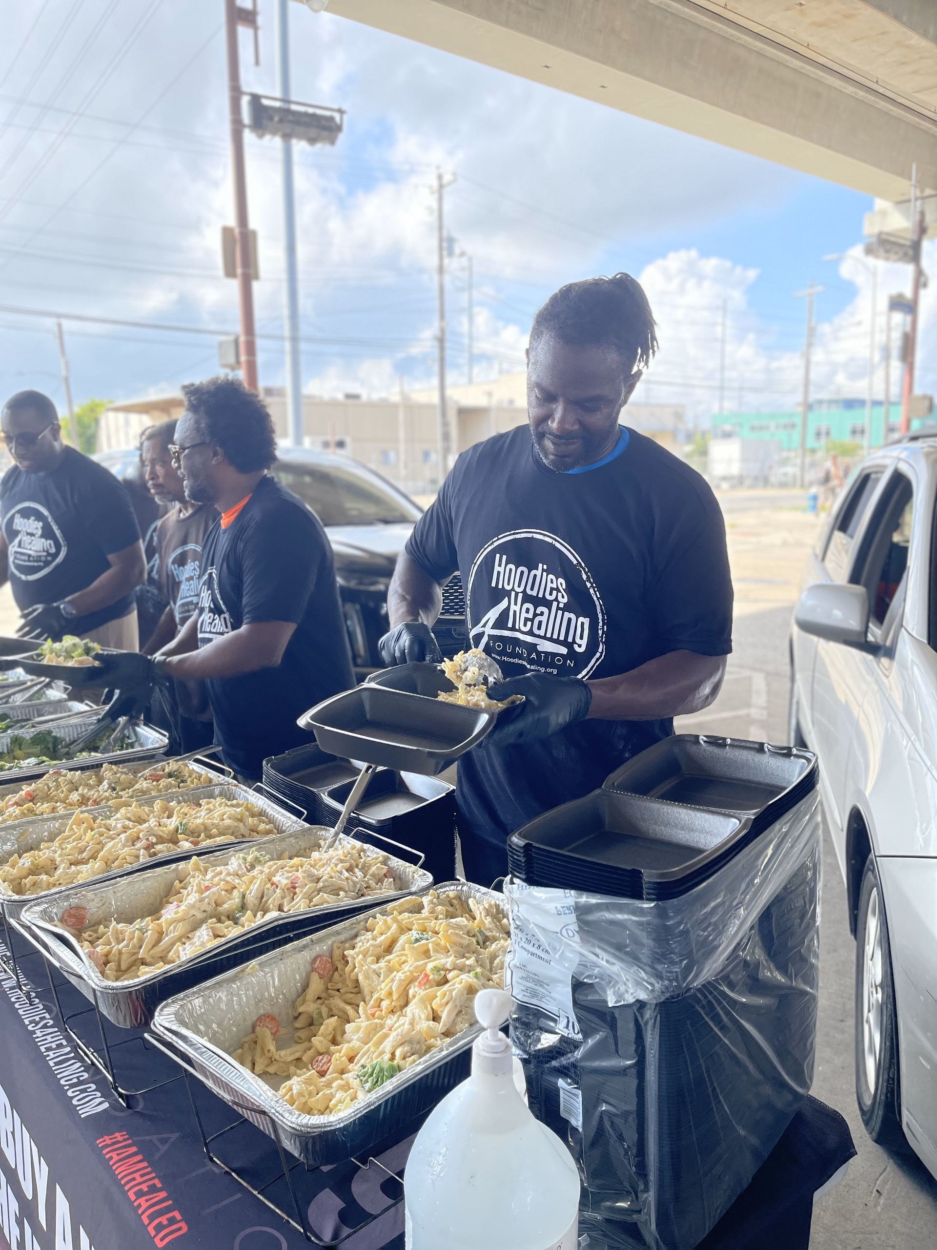 A group of people are standing around a table serving food.