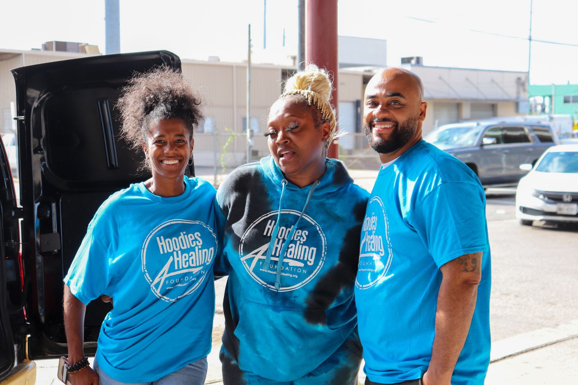 A group of people wearing blue shirts are posing for a picture.