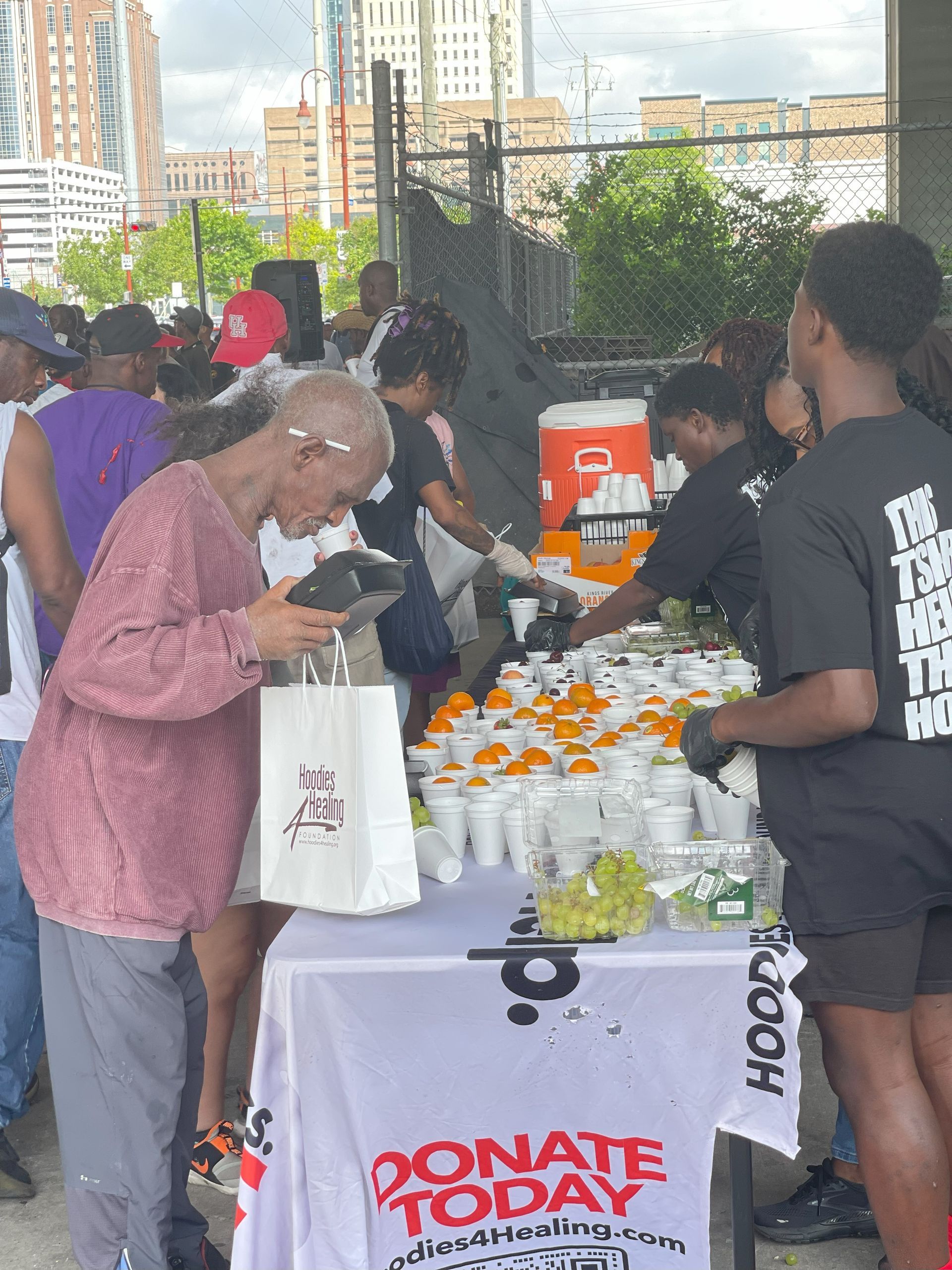 A group of people are standing around a table that says donate today
