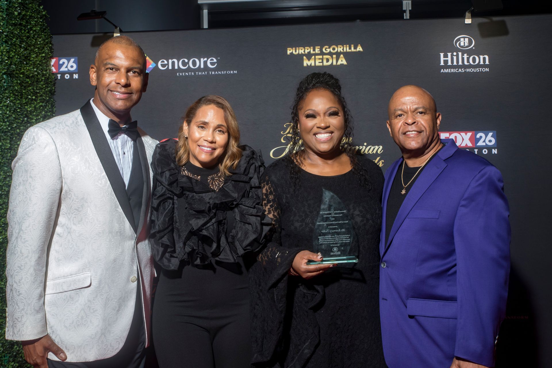A group of people standing next to each other holding a trophy.