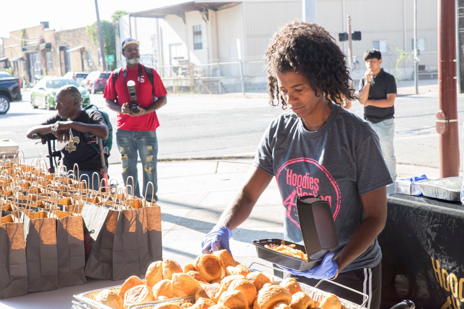 A woman is standing in front of a table filled with food.