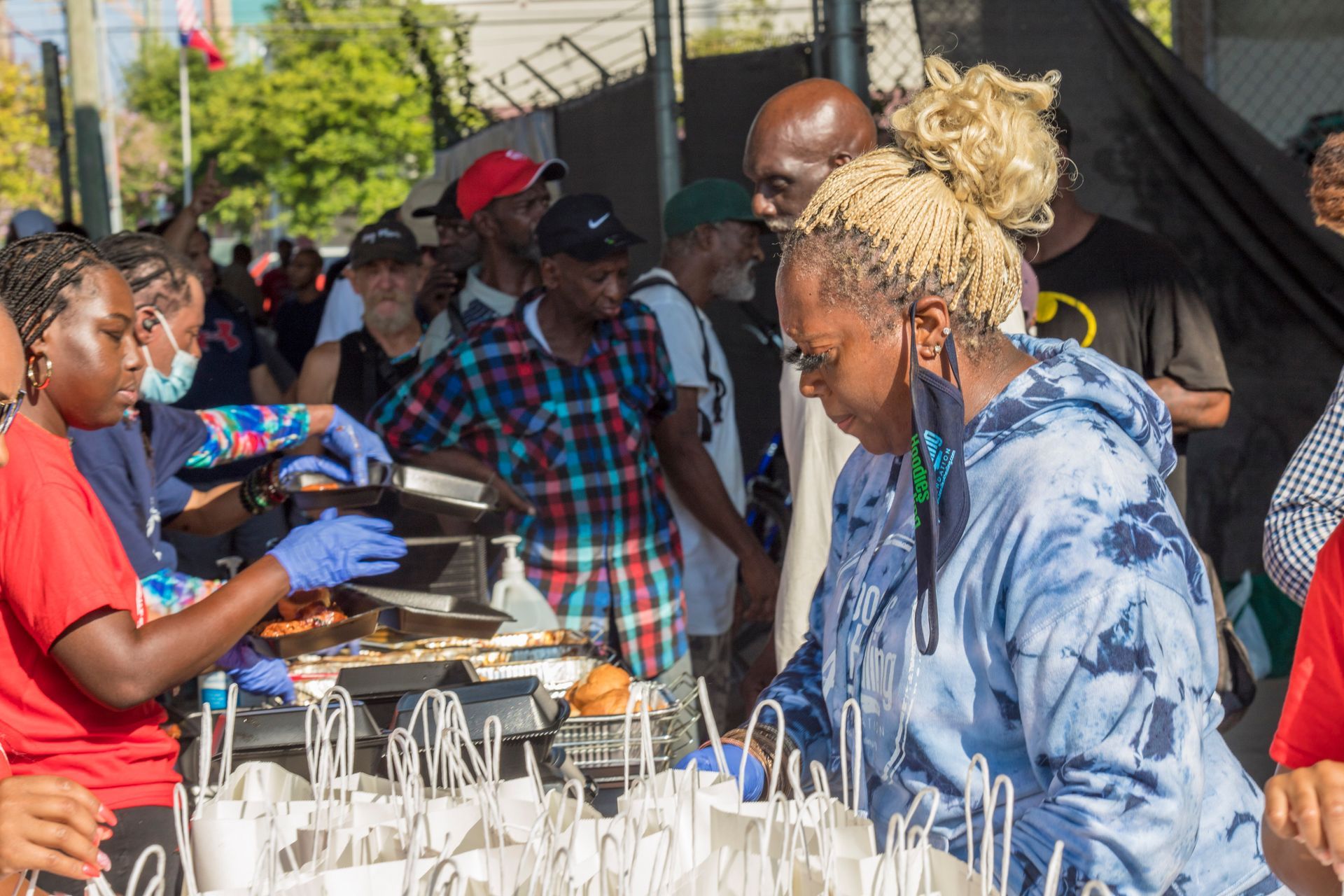 A woman is serving food to a crowd of people at a food festival.