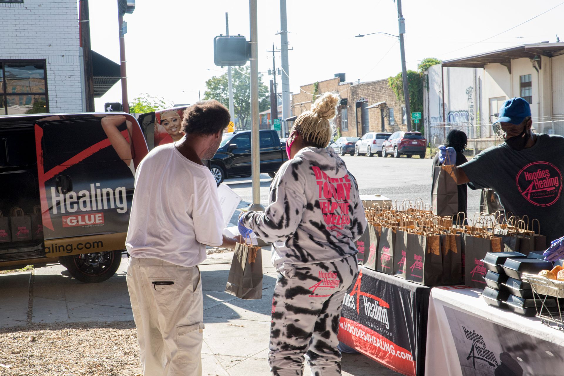 A man and a woman are standing in front of a healing solution van.