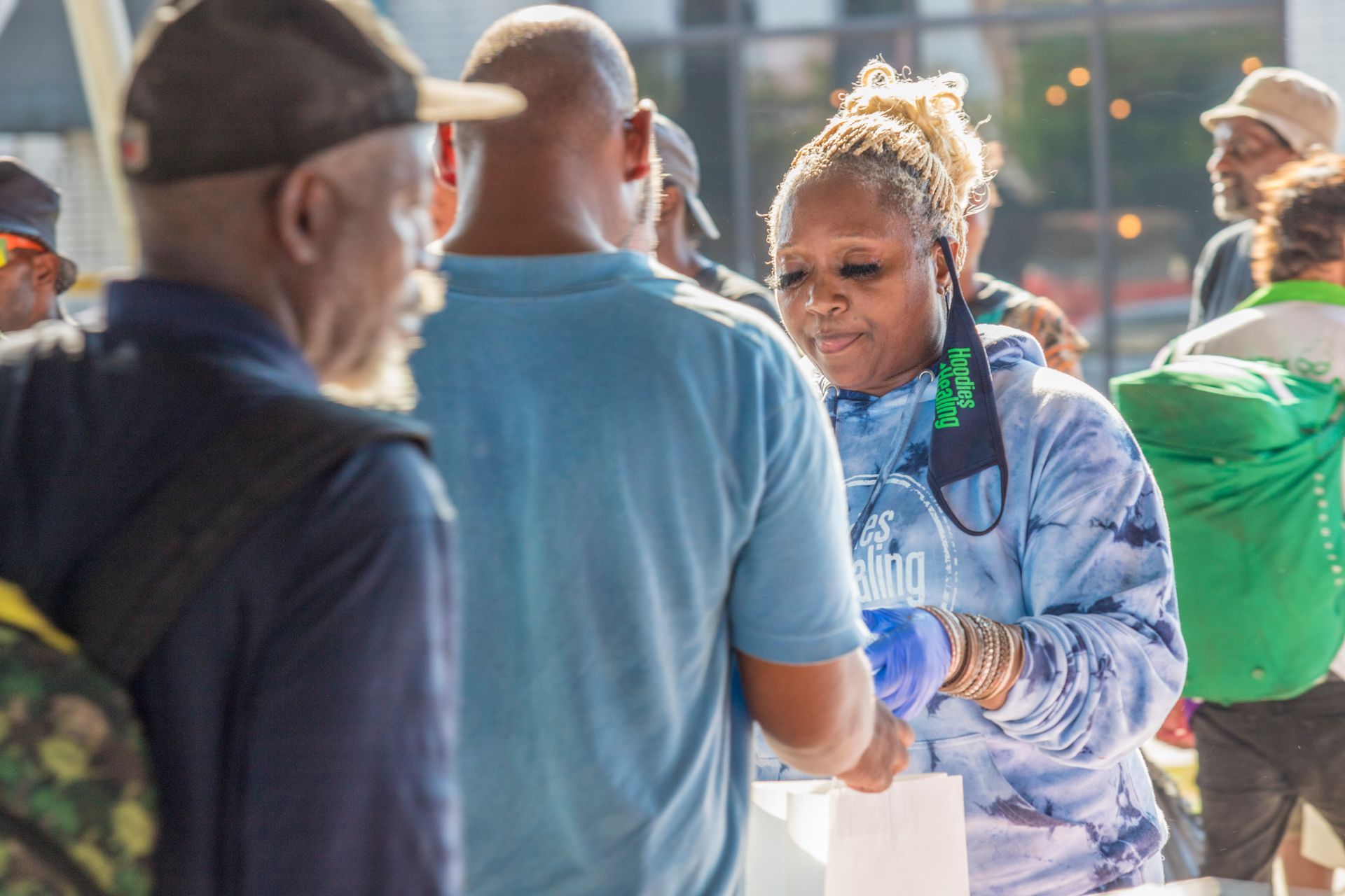 A group of people are standing around a table talking to each other.