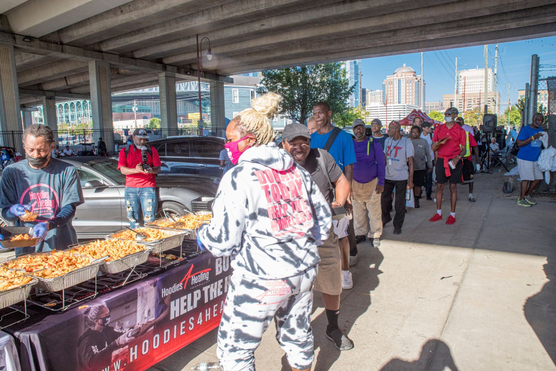 A woman in a zebra print outfit is standing in front of a table with pizza.