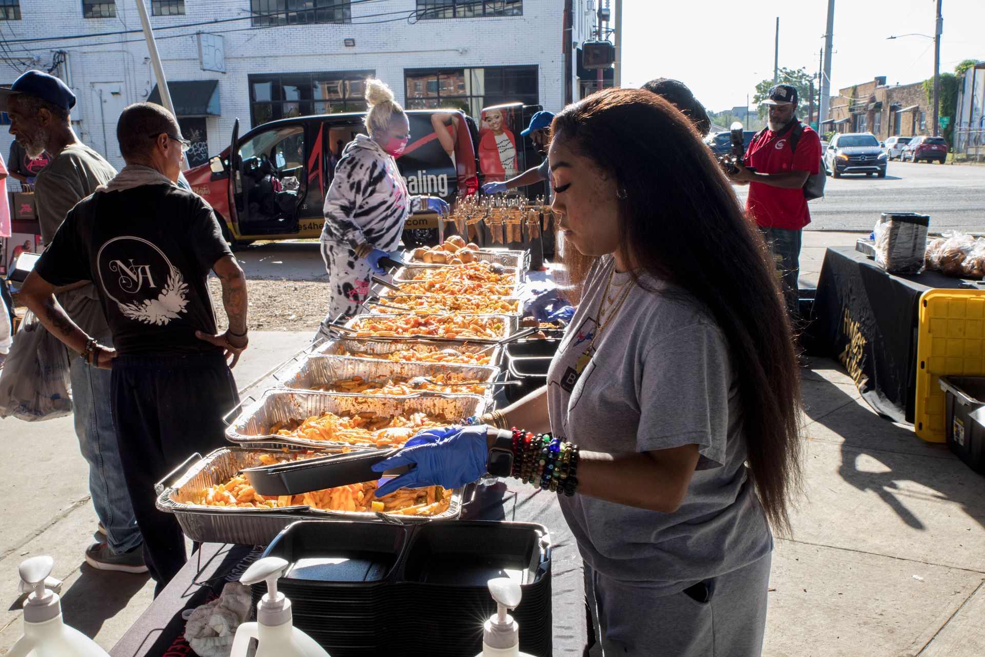 A woman is serving food to a group of people at a table.