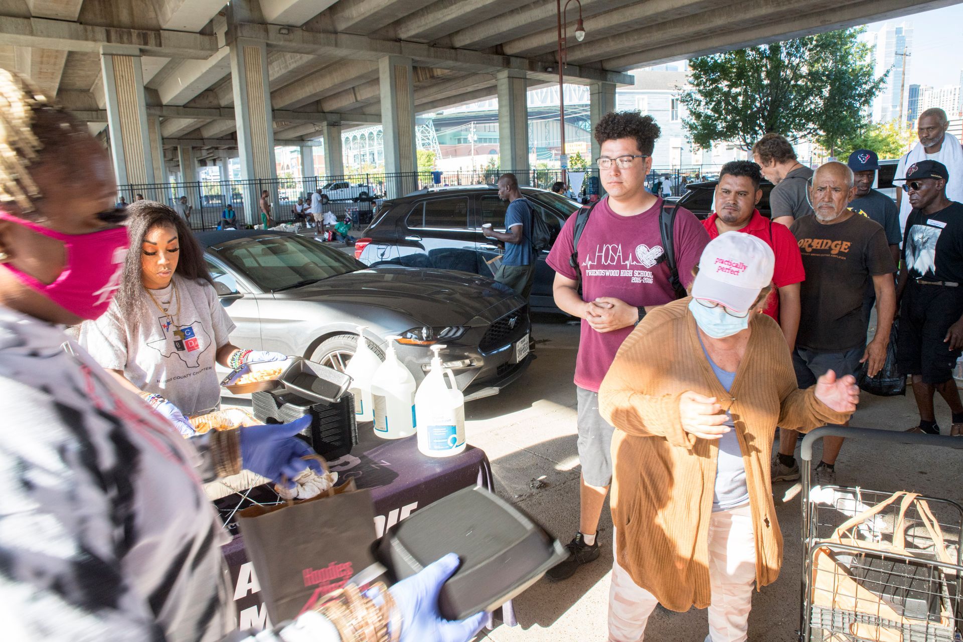 A group of people are standing in a parking lot.