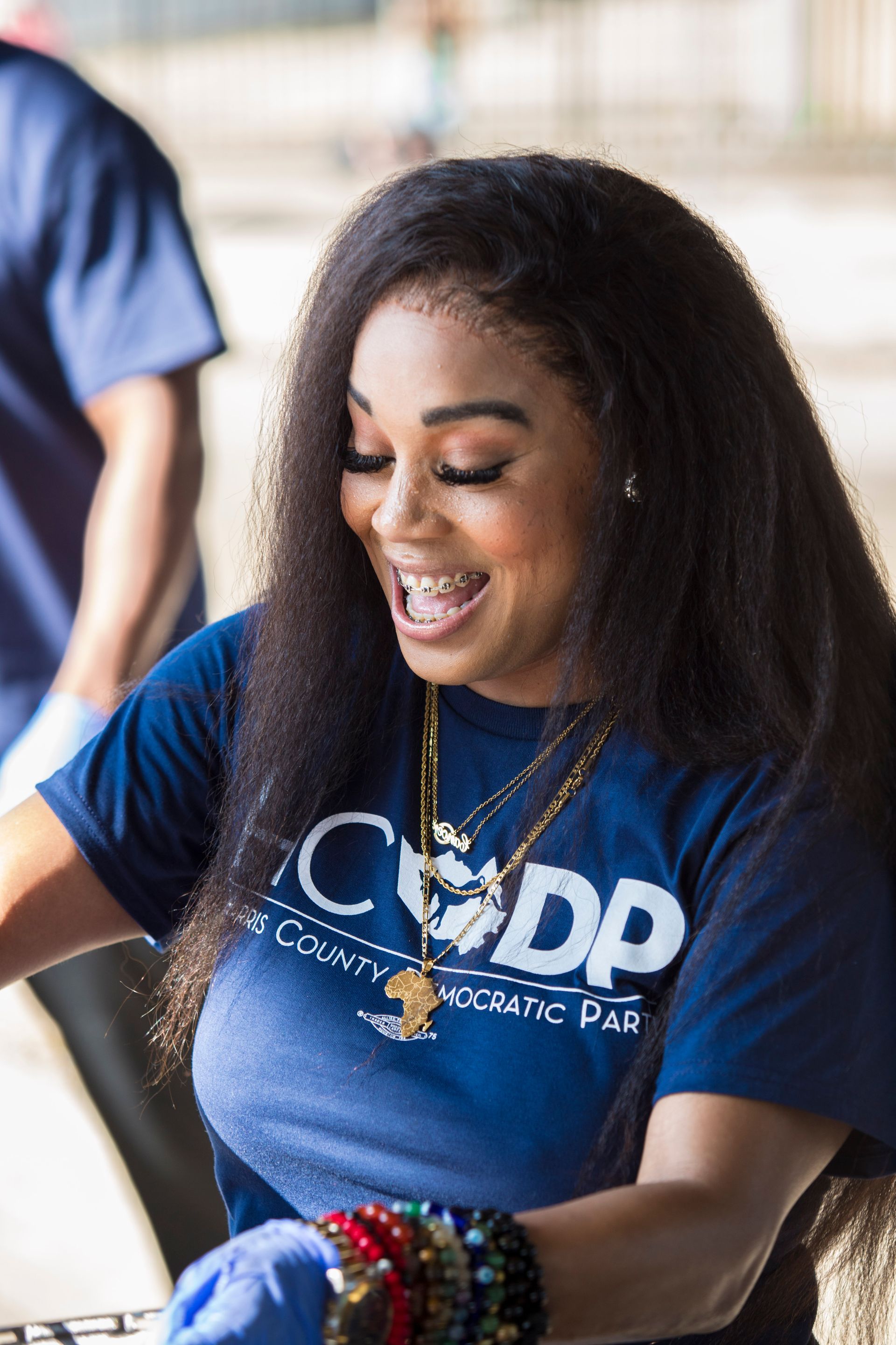 A woman wearing a blue t-shirt with the word cdc on it is smiling.