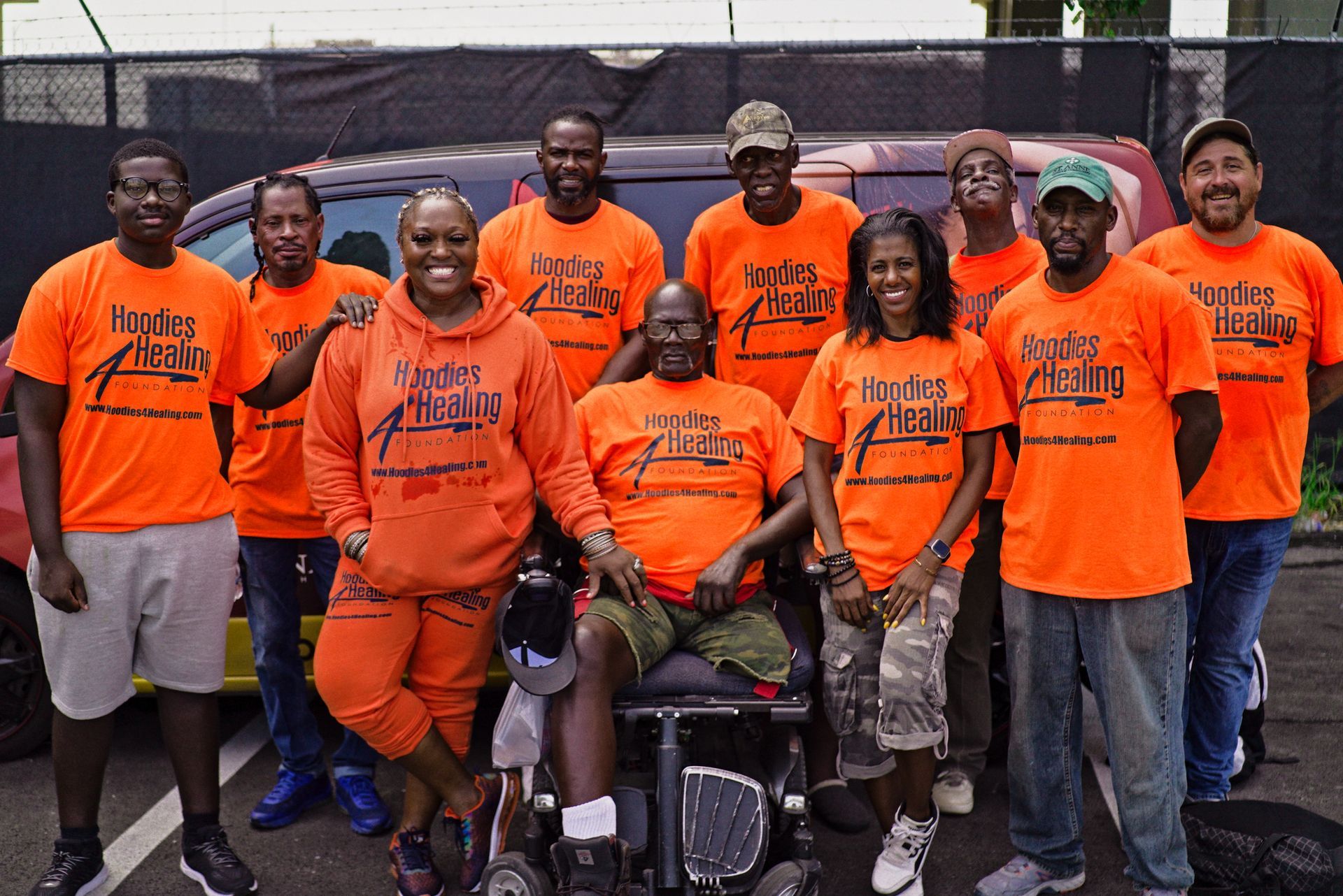 A group of people wearing orange shirts are posing for a picture
