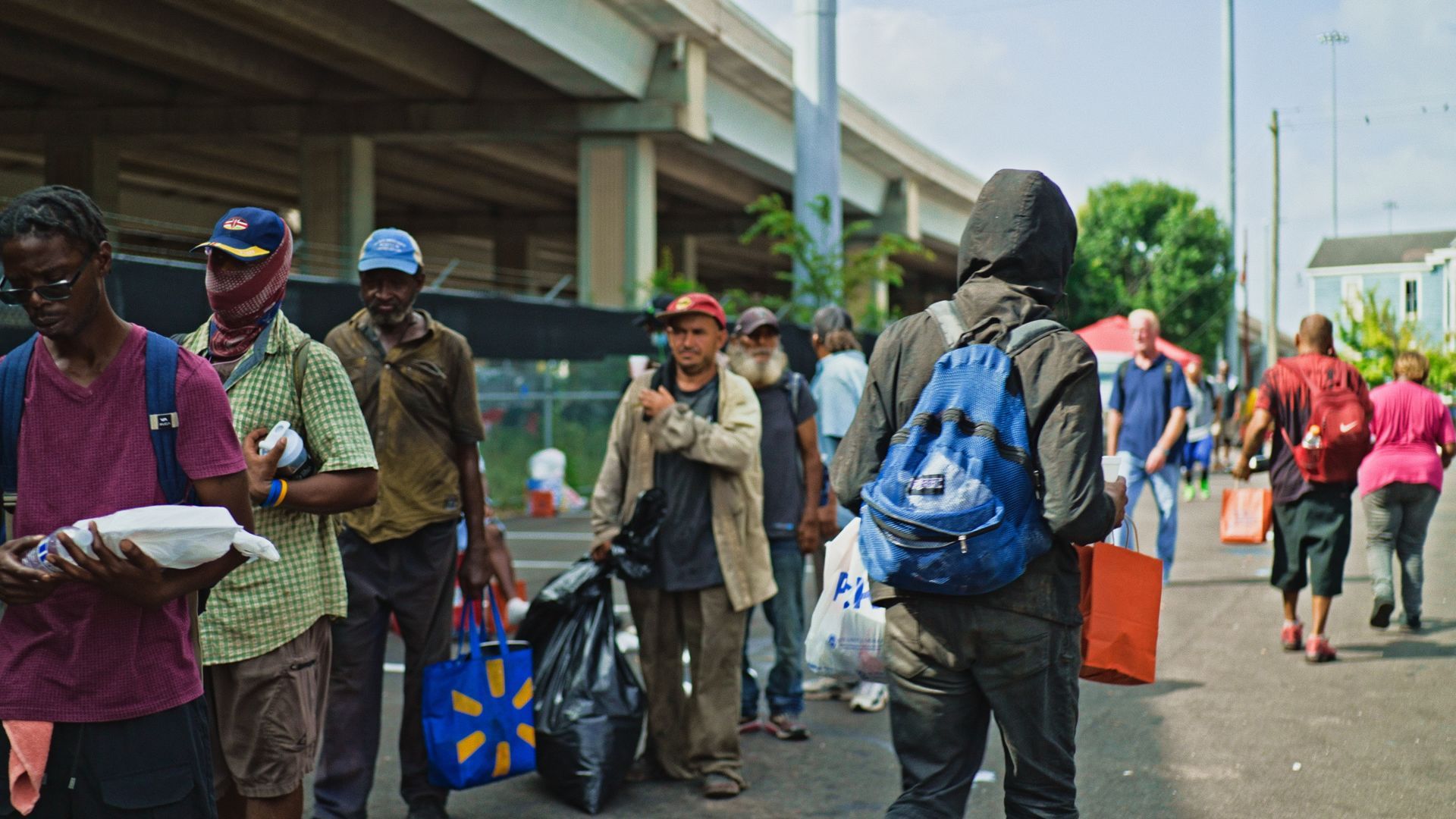 A group of people are standing on the side of the road.