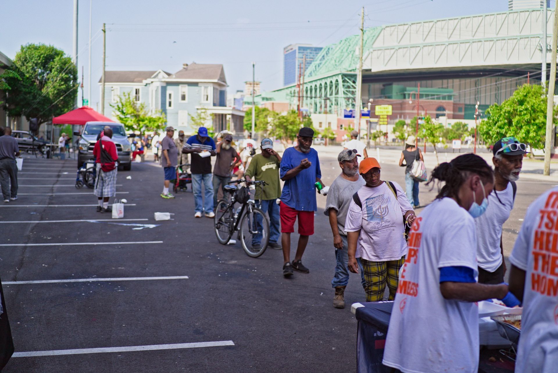 A group of people are standing in a parking lot.