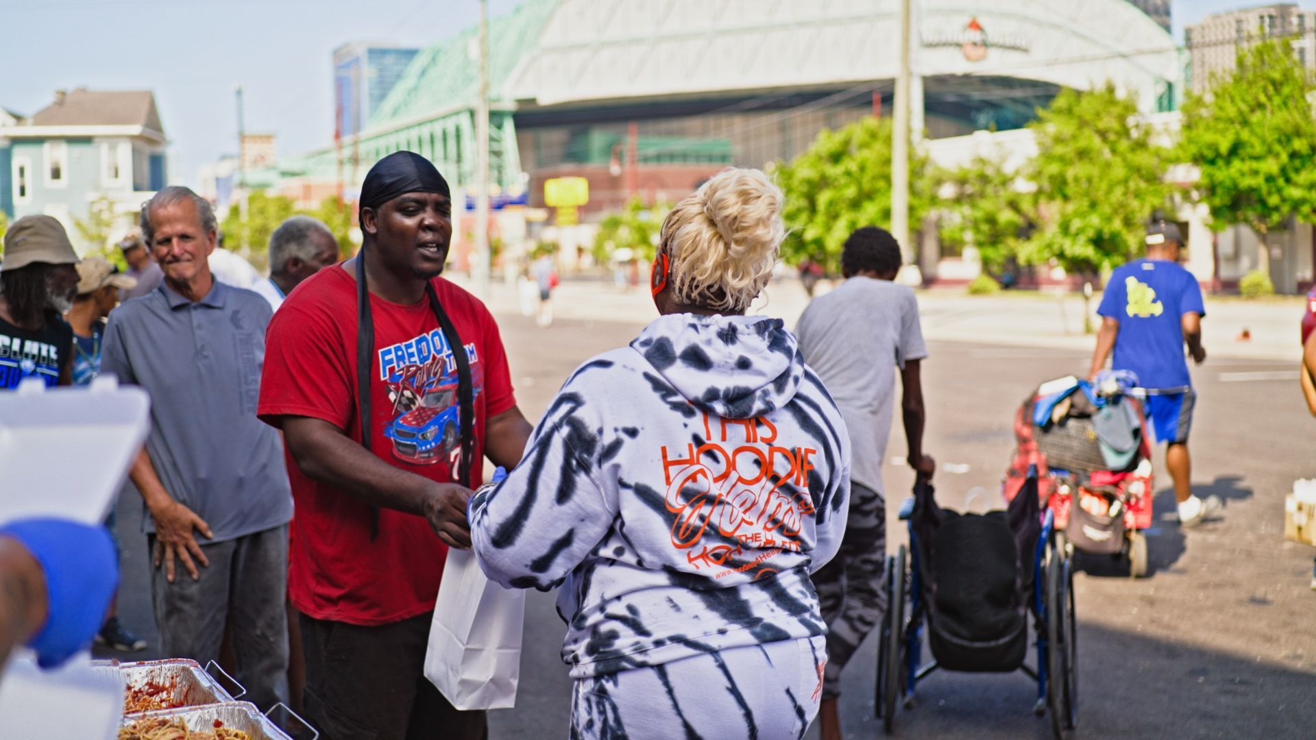A man is shaking hands with a woman in a wheelchair.