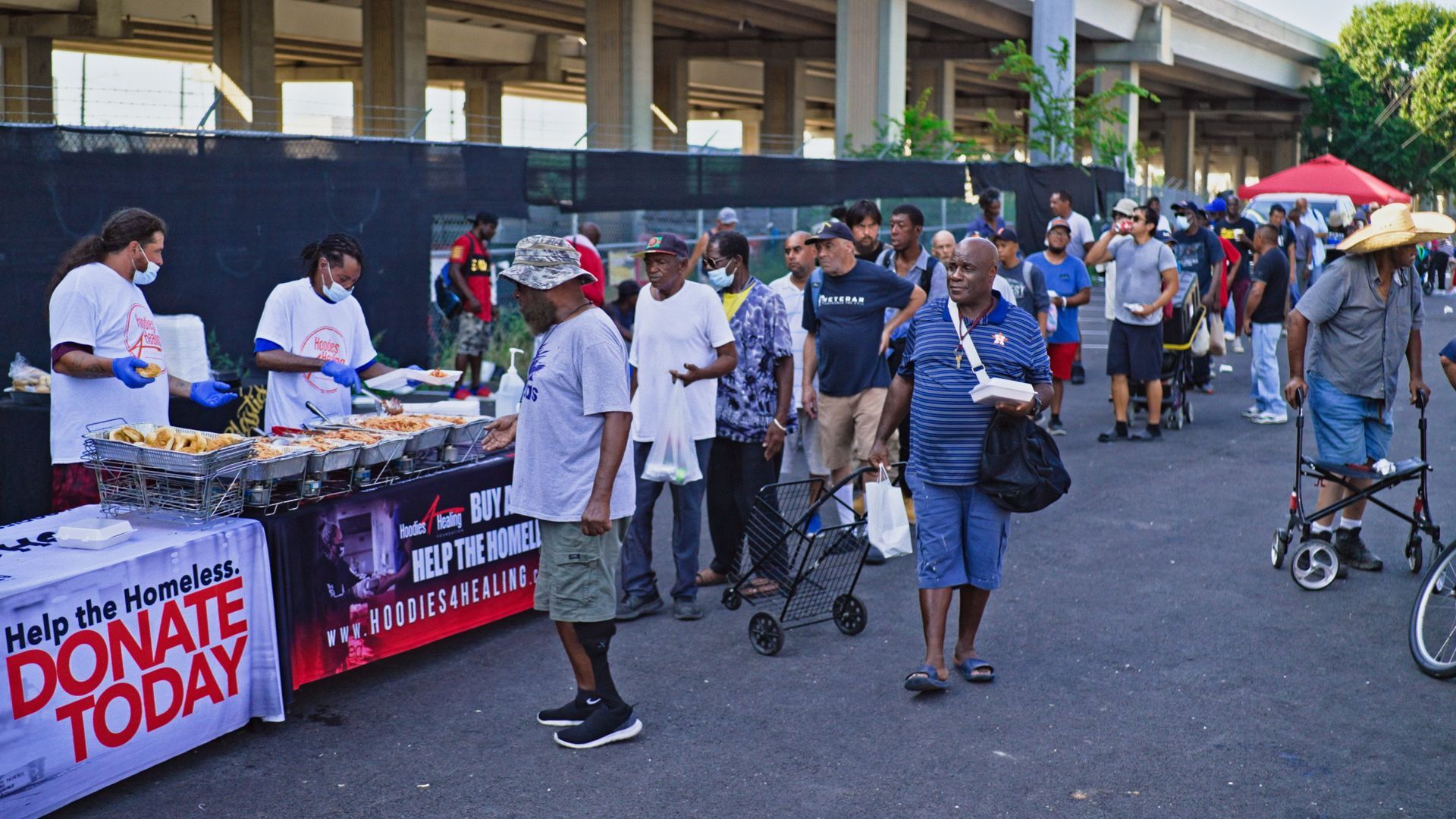 A group of people are standing around a table that says donate today.