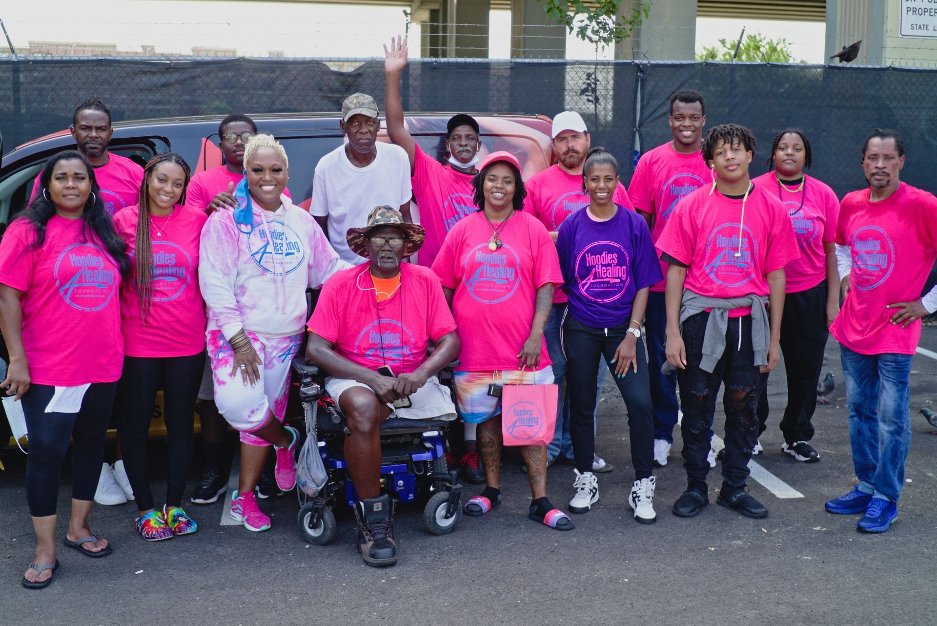 A group of people wearing pink shirts are posing for a picture.
