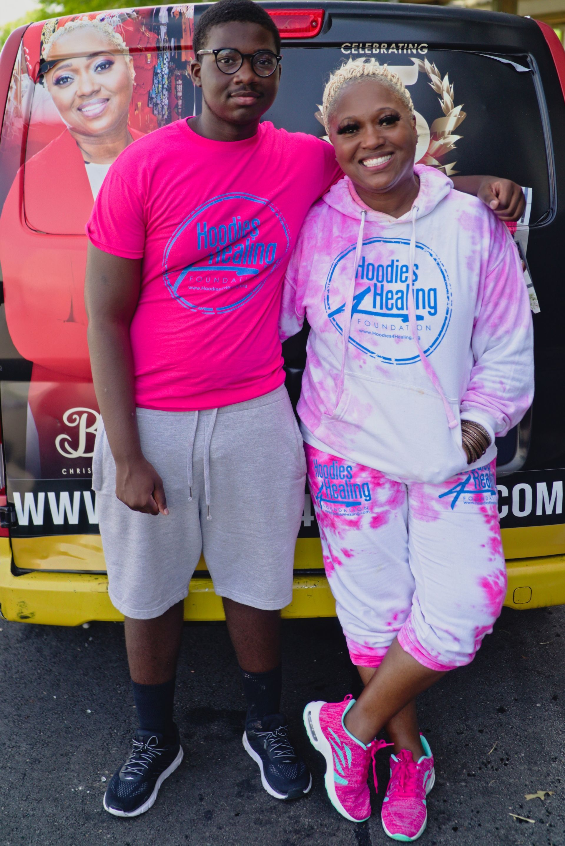 A man and a woman are standing next to each other in front of a van.