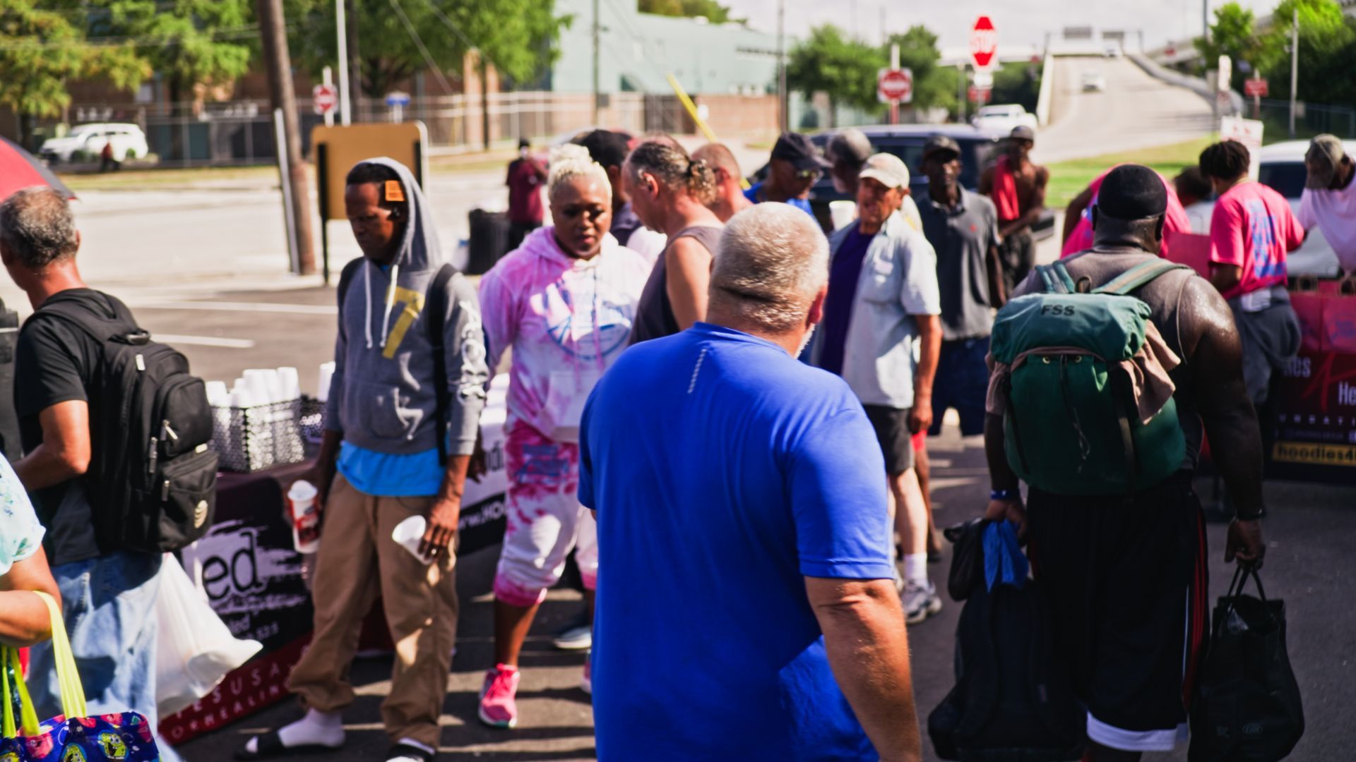 A group of people are standing on the side of the road.