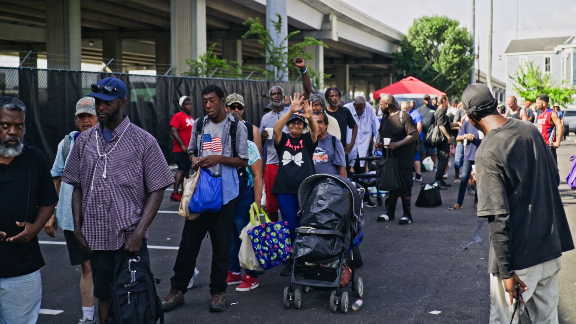 A group of people are standing on the side of the road.