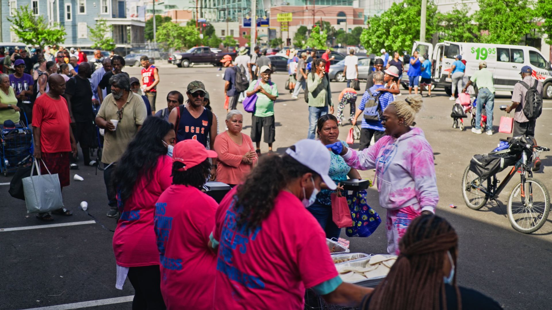 A group of people are standing in a parking lot.