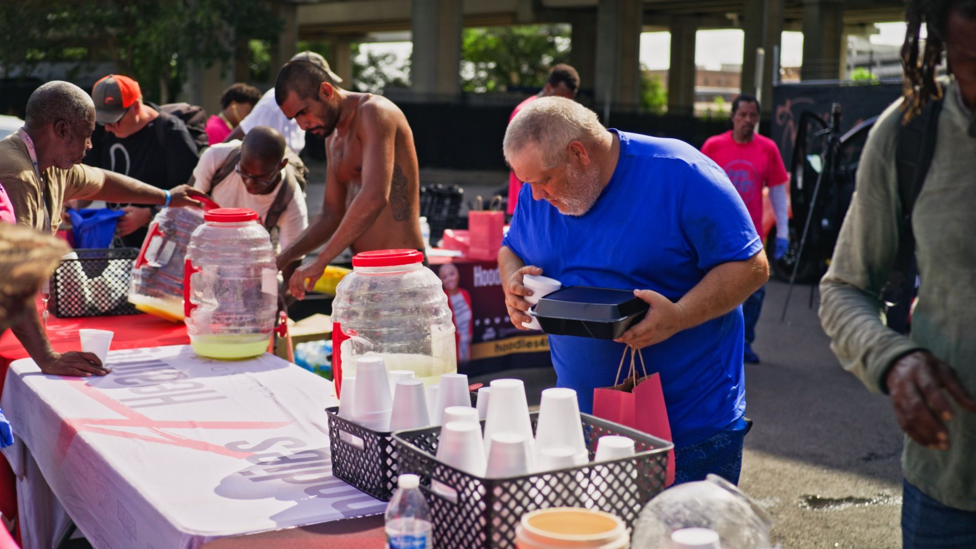A group of people are standing around a table with cups on it.