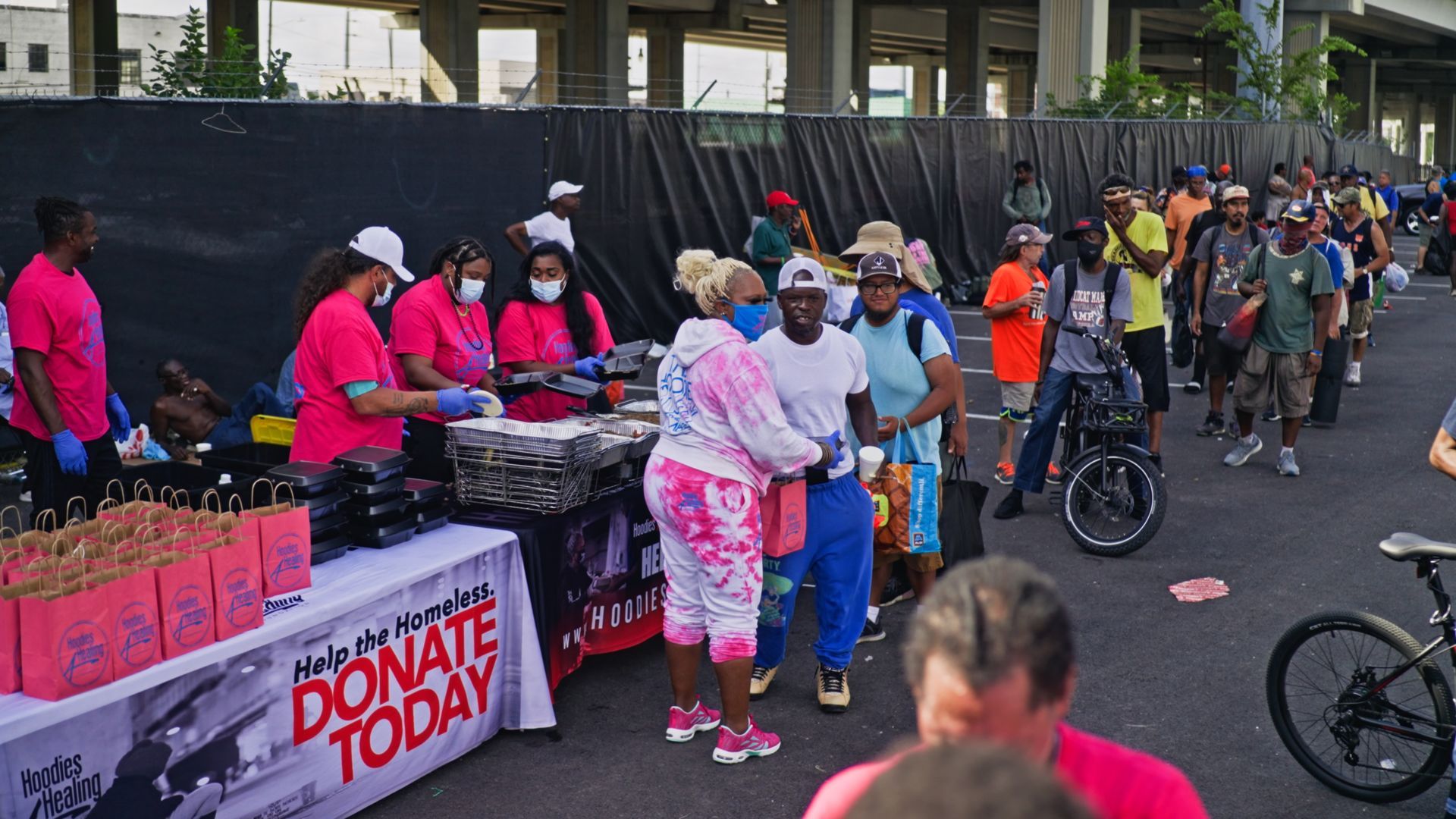 A group of people are standing around a table that says donate today.