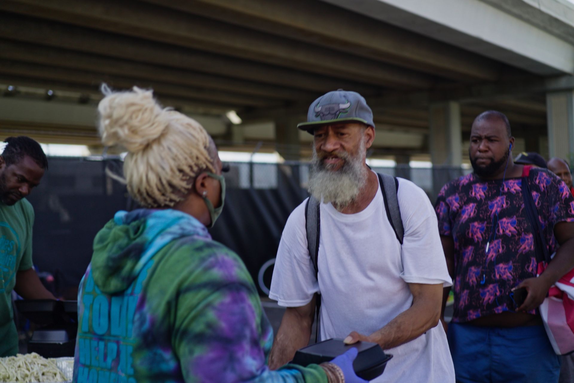 A man with a beard is shaking hands with a woman.