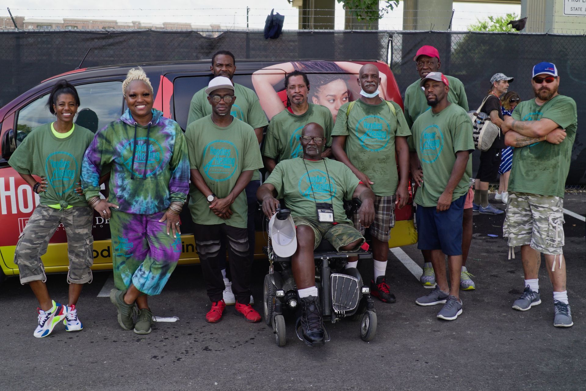 A group of people posing for a picture in front of a van that says ho