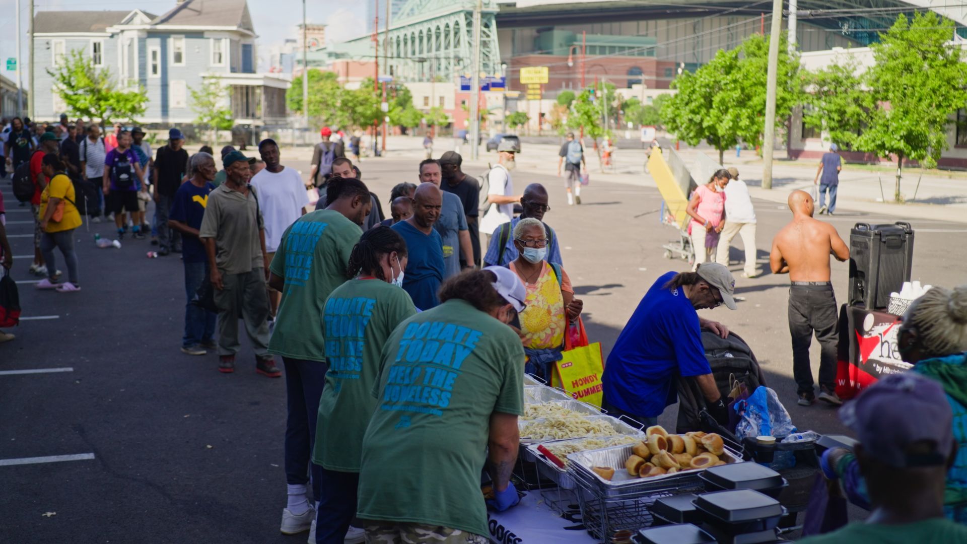 A group of people are standing around a table in a parking lot.