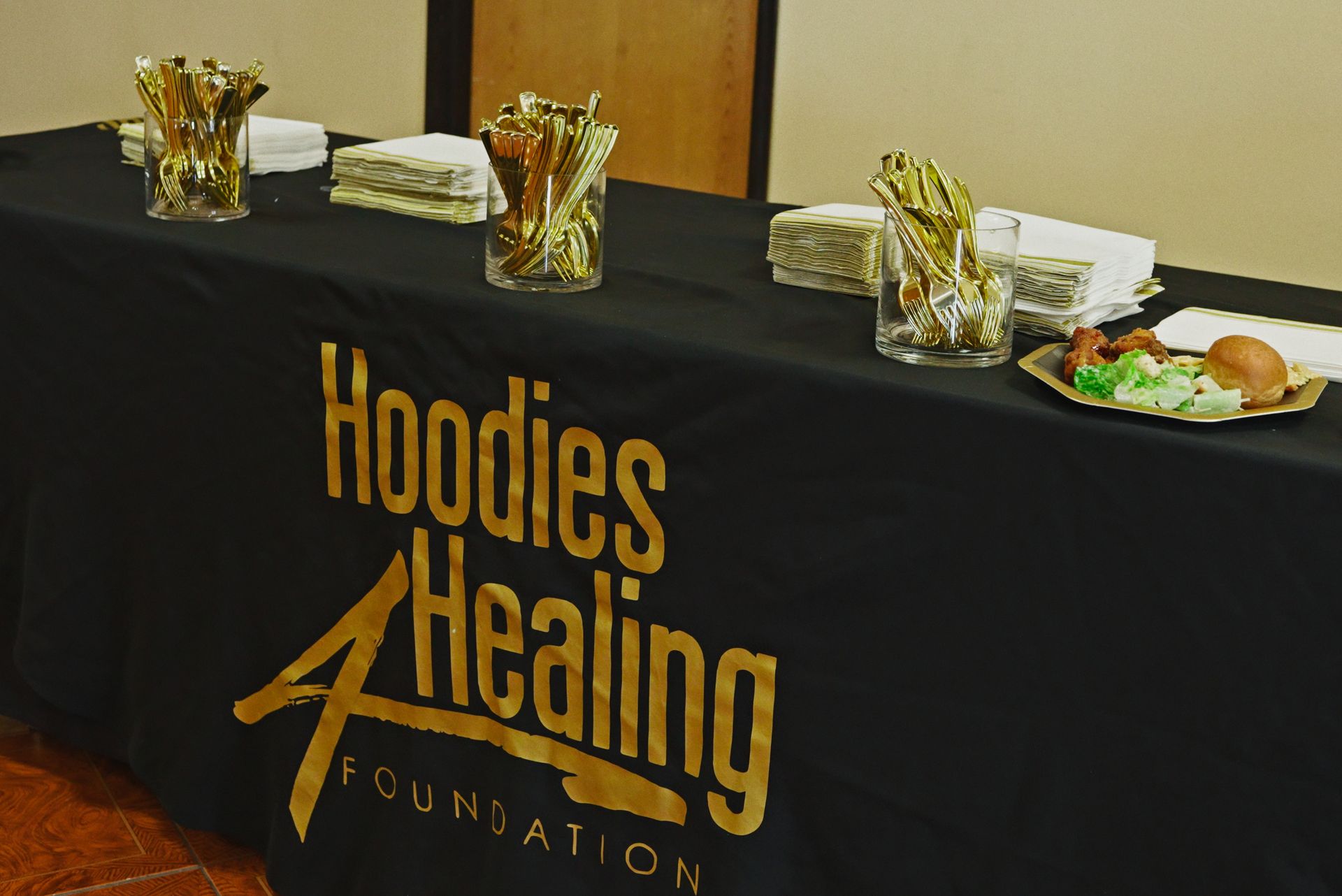 A table with a black table cloth that says hoodies healing foundation