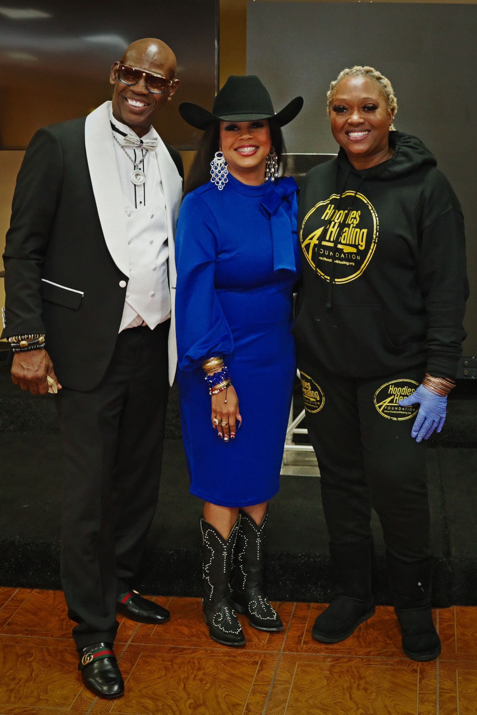 A man in a tuxedo and a woman in a blue dress pose for a picture