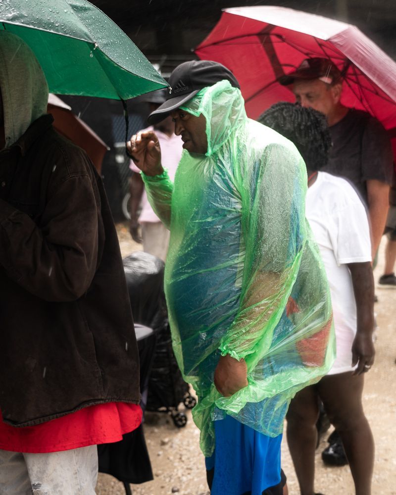 A group of people standing under umbrellas in the rain