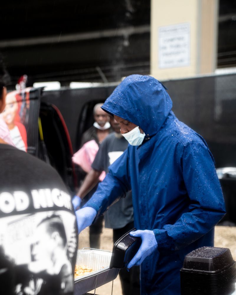 A man wearing a mask and a blue jacket that says good high