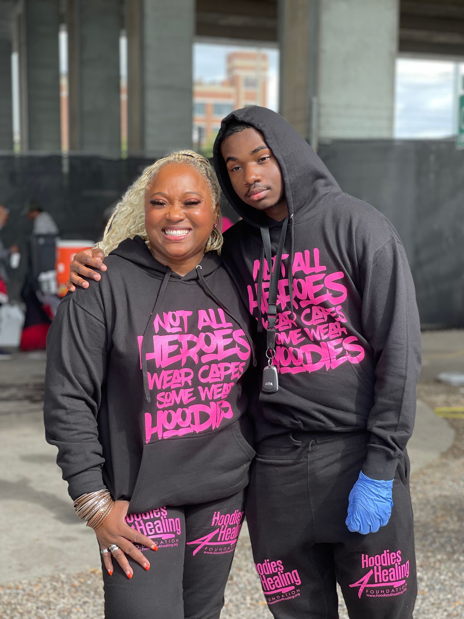 A man and a woman are standing next to each other wearing hoodies.