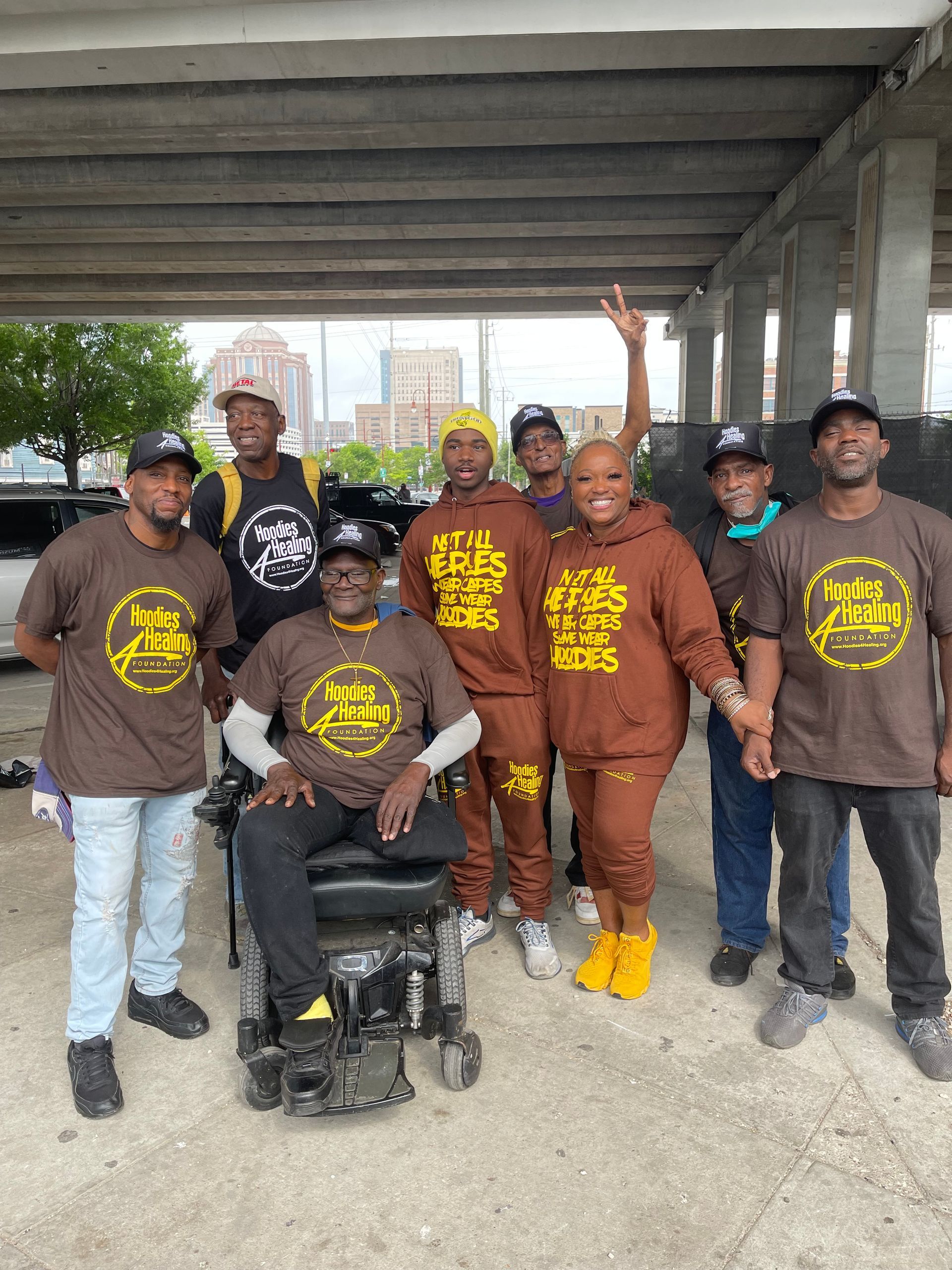 A group of people are posing for a picture with a man in a wheelchair.