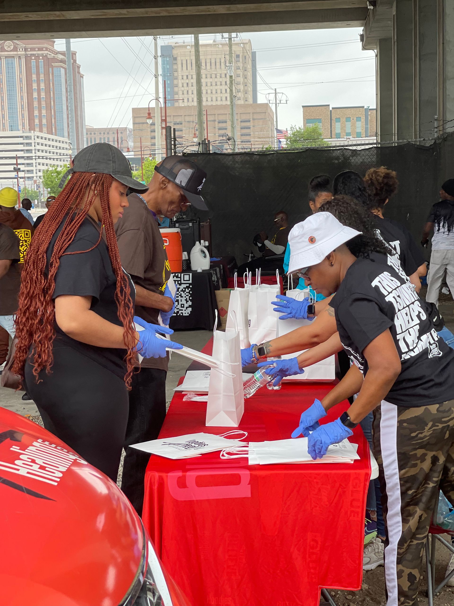 A group of people are standing around a table.