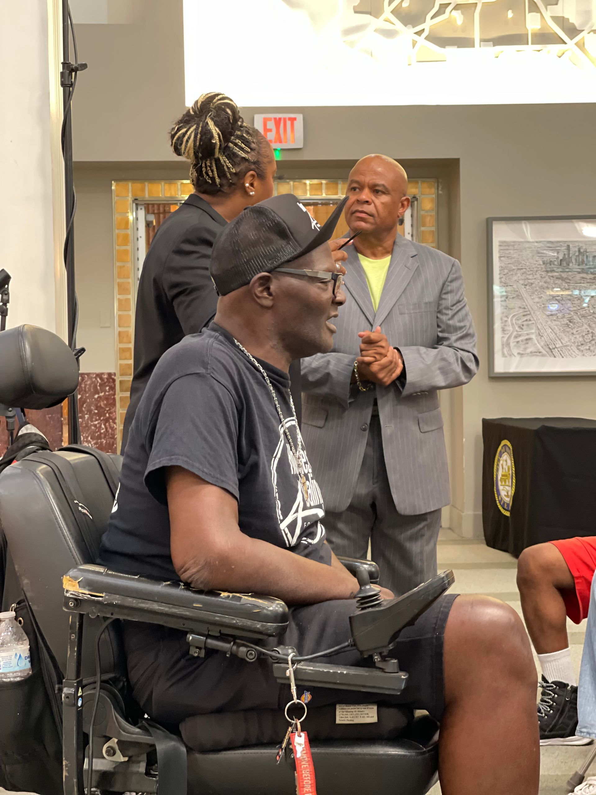 A man in a wheelchair is talking to another man in a suit