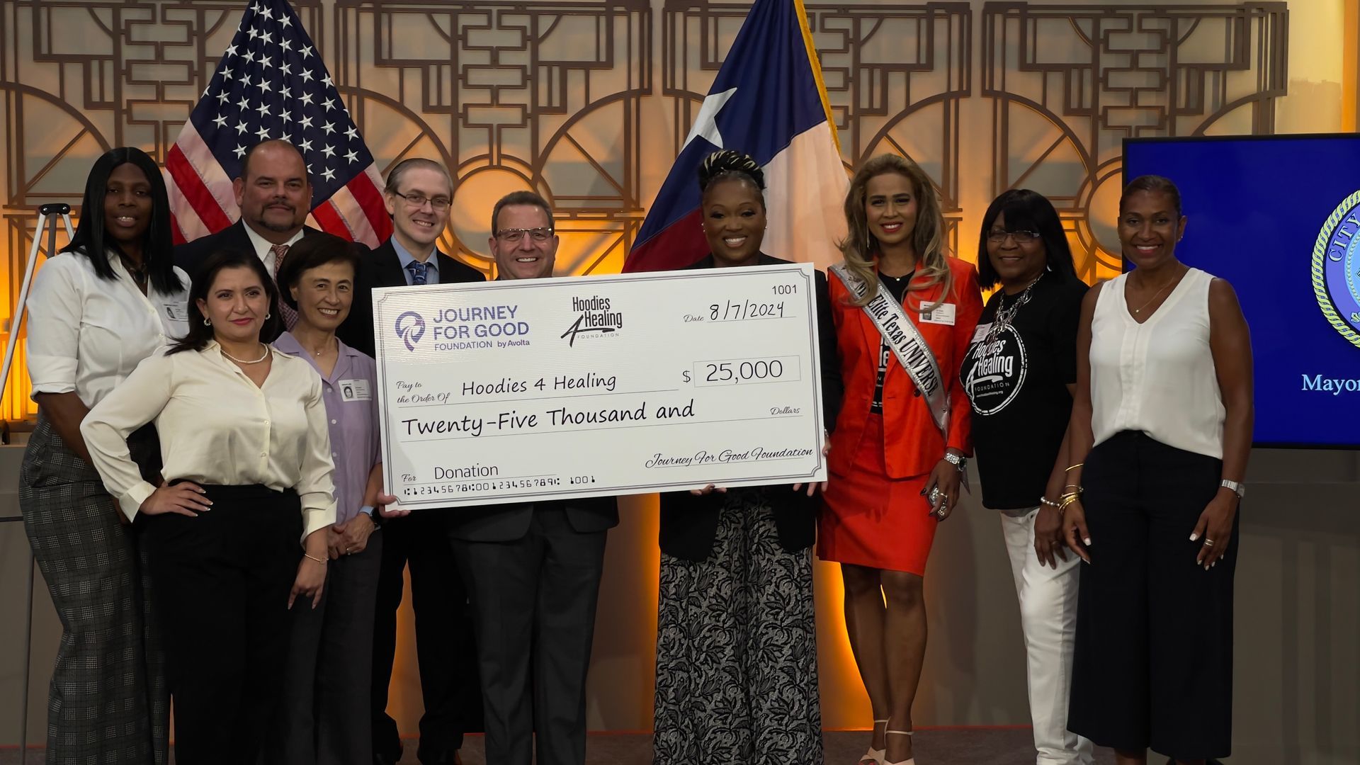 A group of people standing next to each other holding a large check.